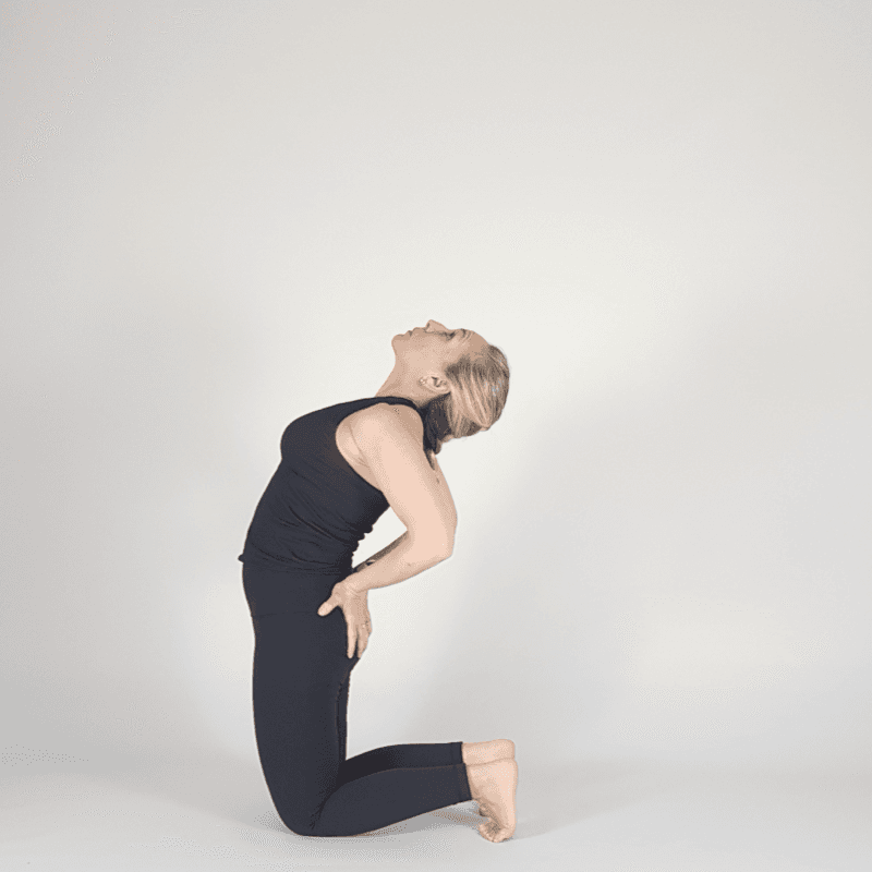 Yoga practitioner in Camel Pose with hands supporting hips