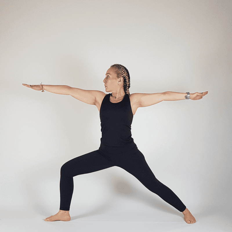 Yoga practitioner in Warrior II with front knee bent and arms extended
