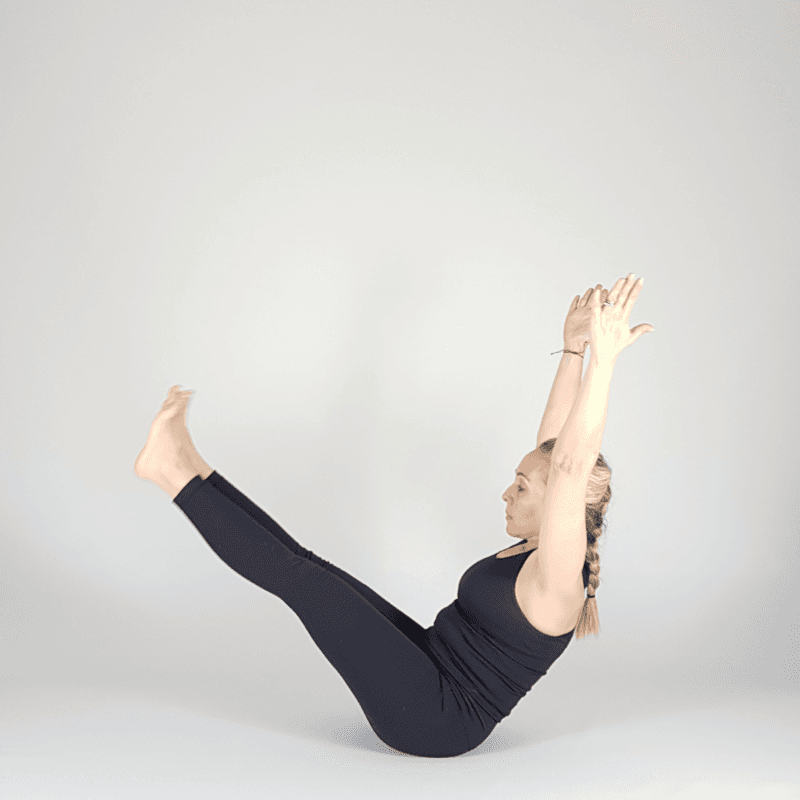 Yoga practitioner releasing from Boat Pose.