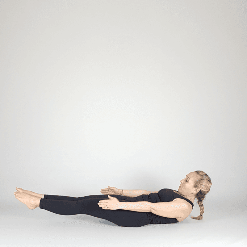 Yoga practitioner extending legs supine.