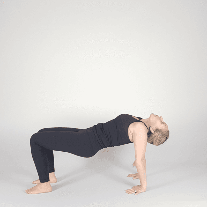 Yoga practitioner lifting hips in Reverse Tabletop position.