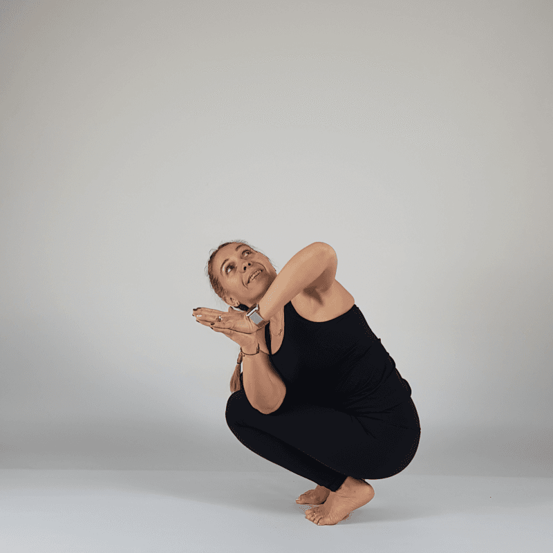 Yoga practitioner performing twisting Garland Pose.