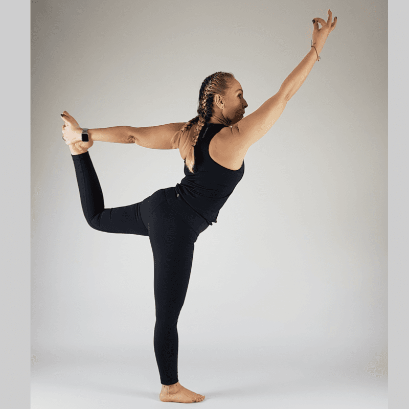 Back view of yoga practitioner in full Dancer Pose showing spinal arch and leg extension