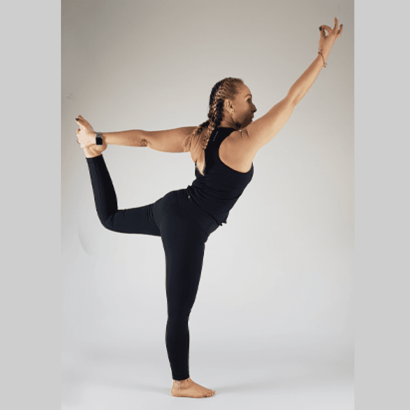 Yoga practitioner in Dancer Pose balancing on one leg with back foot lifted and held