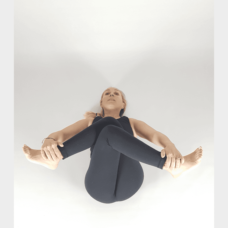 Yoga practitioner in Supine Figure Four stretch.