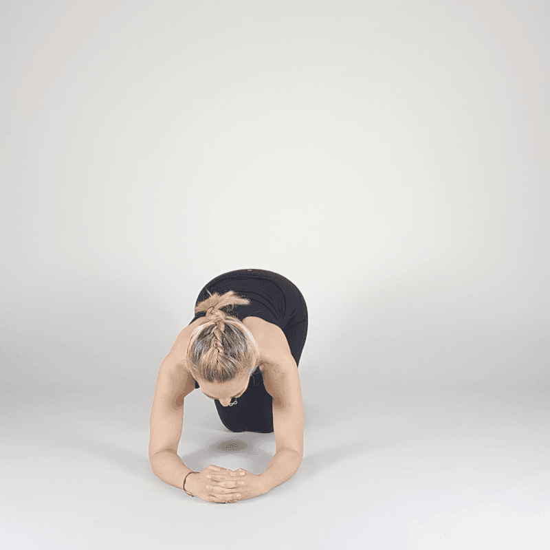 Yoga practitioner holding Forearm Plank position.