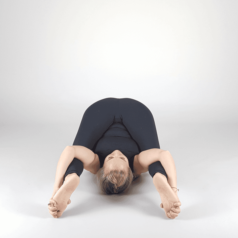 Yoga practitioner in deep Happy Baby pose.