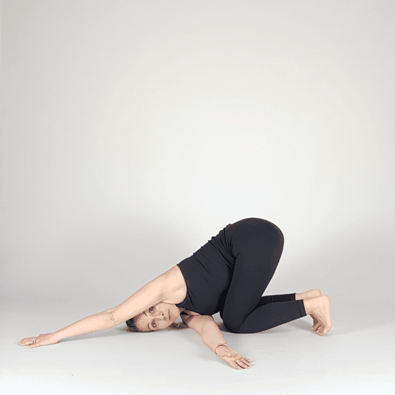 Yoga practitioner in Thread the Needle pose with arm threaded under body
