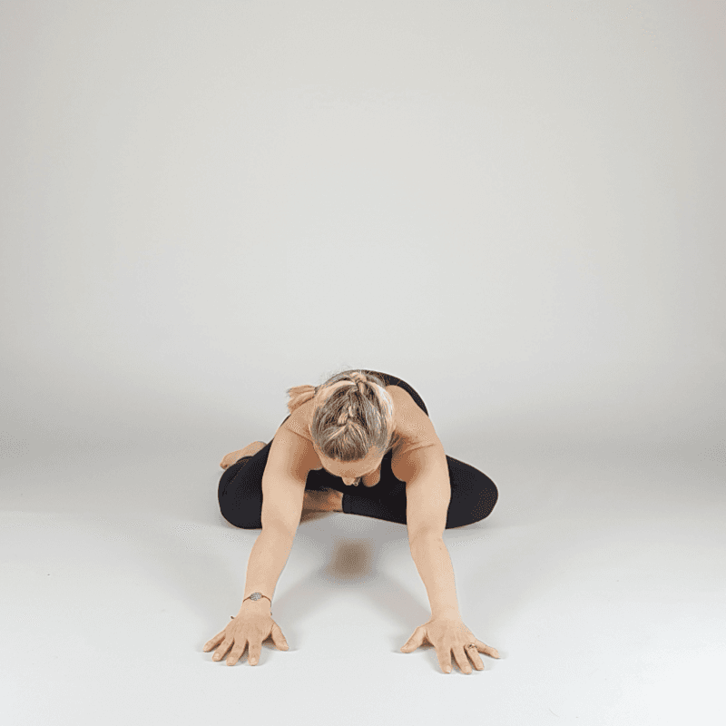 Yoga practitioner resting in a seated forward fold.