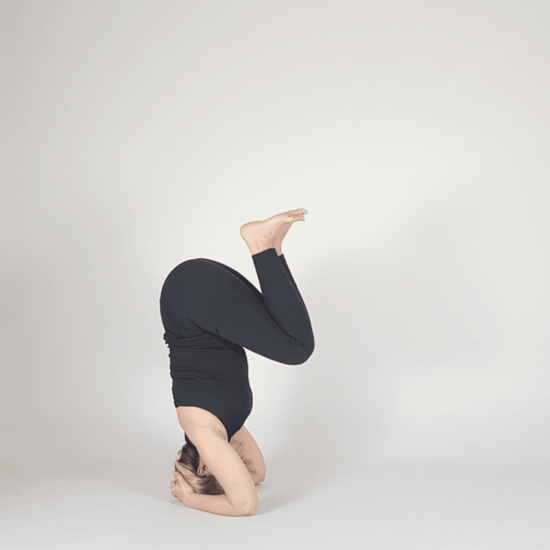 Yoga practitioner in tucked Headstand position.