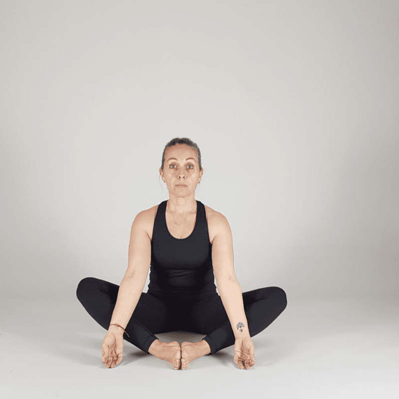 Yoga practitioner performing a seated shoulder bind.