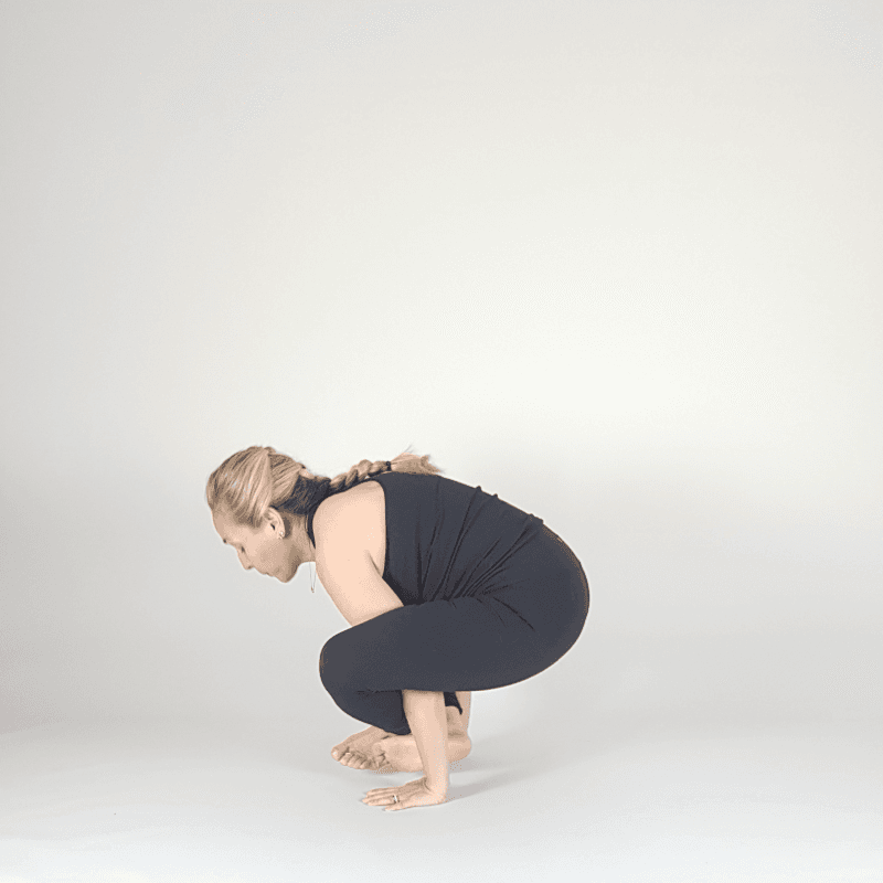 Yoga practitioner holding confident Crow Pose with legs lifted.