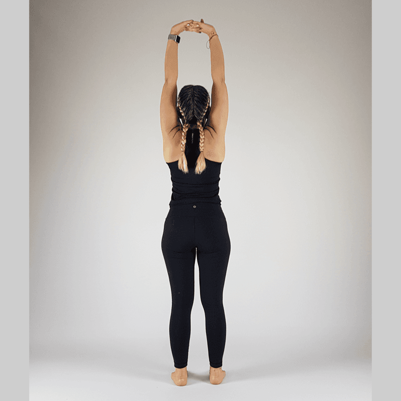 Yoga practitioner in Standing Backbend with hands supporting lower back