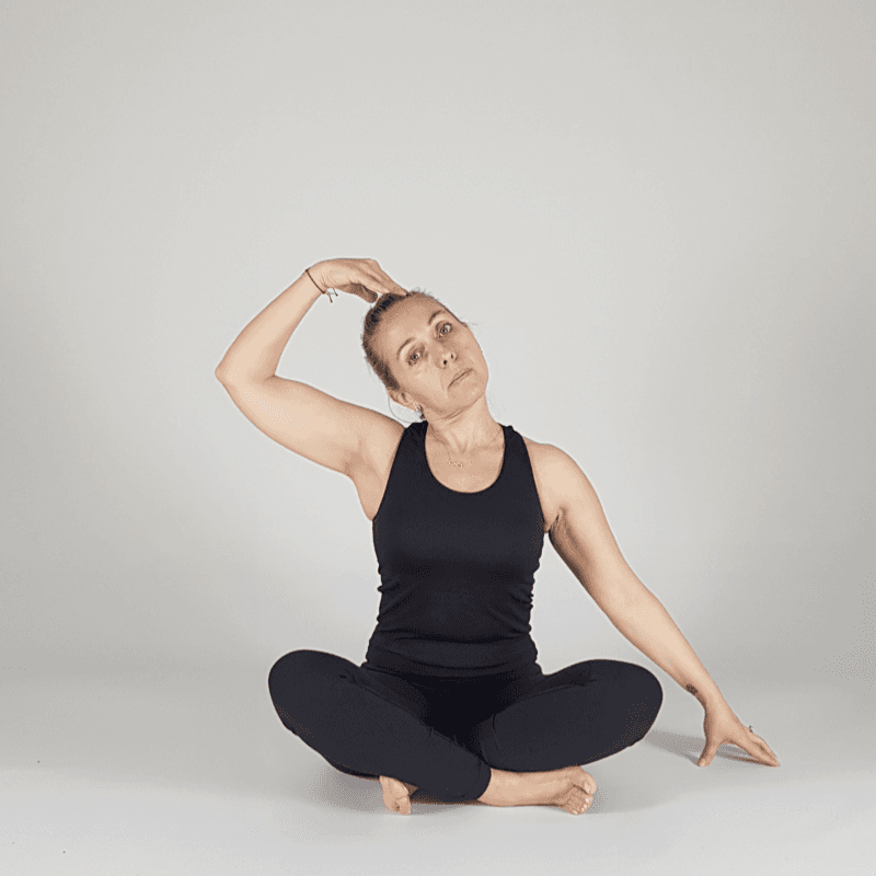 Yoga practitioner performing a seated neck stretch.