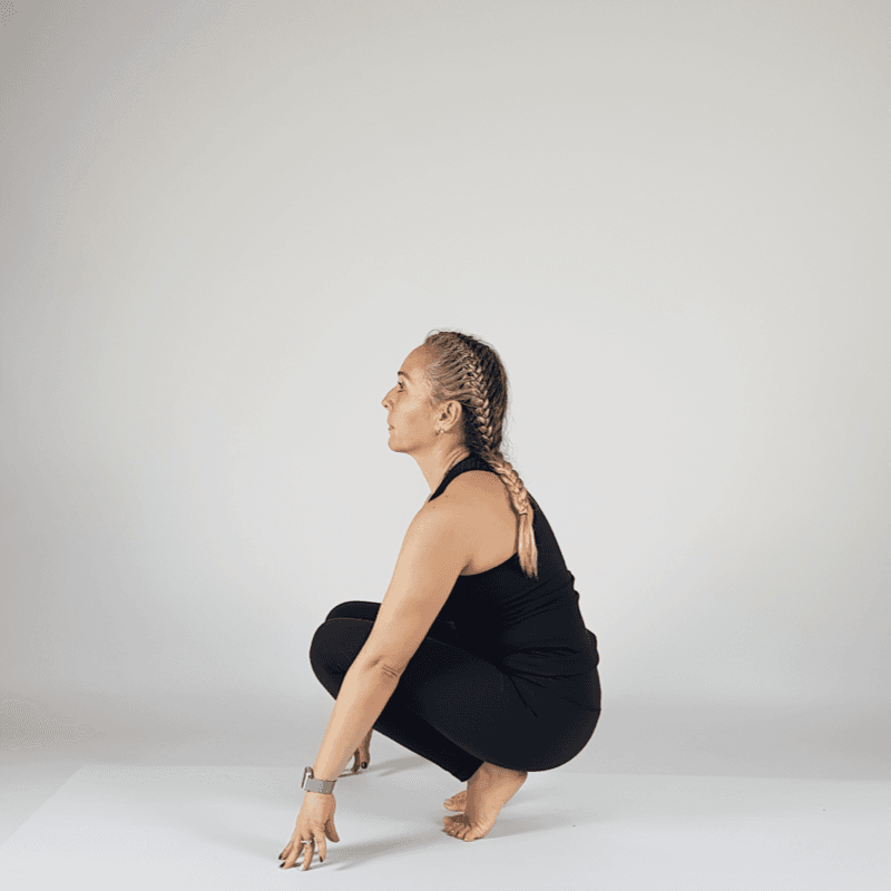 Yoga practitioner in supported Yogi Squat sitting on block