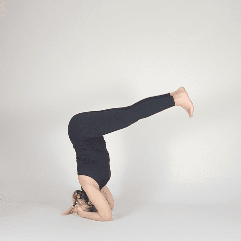 Yoga practitioner holding legs parallel to floor in headstand.