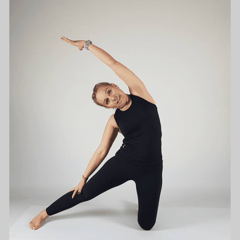 Yoga practitioner performing Kneeling Side Stretch with arm overhead