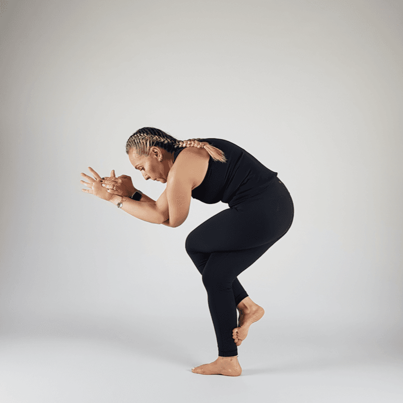Yoga practitioner in Chair Eagle Pose with wrapped arms and bent knees