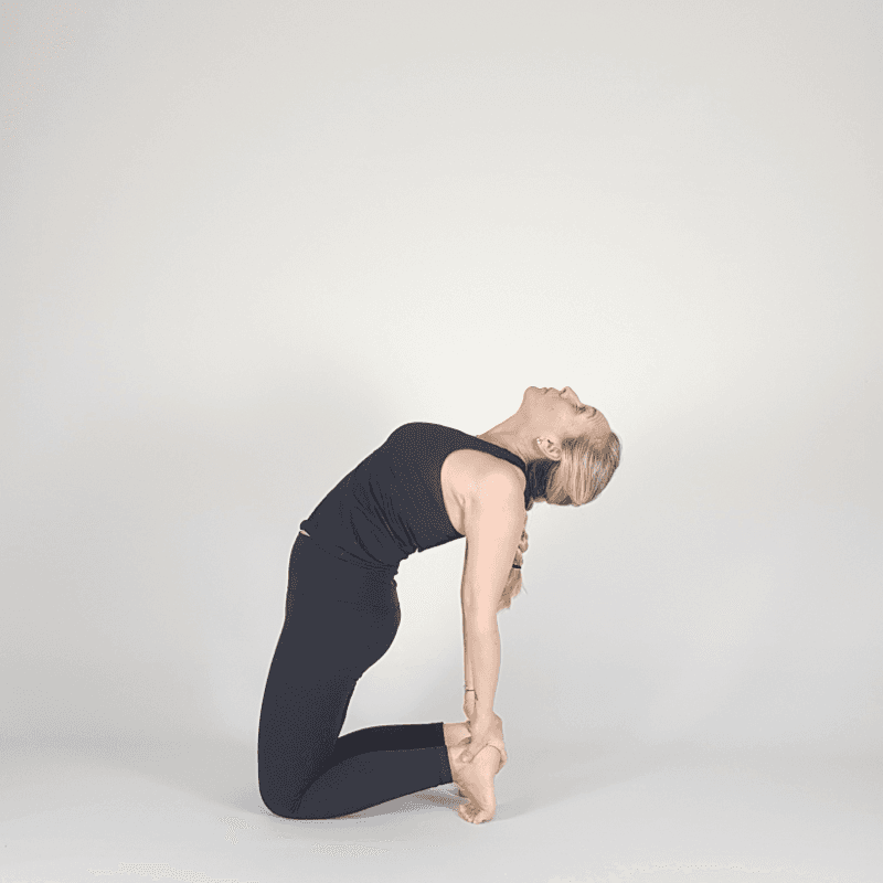 Yoga practitioner in Camel Pose gripping the feet