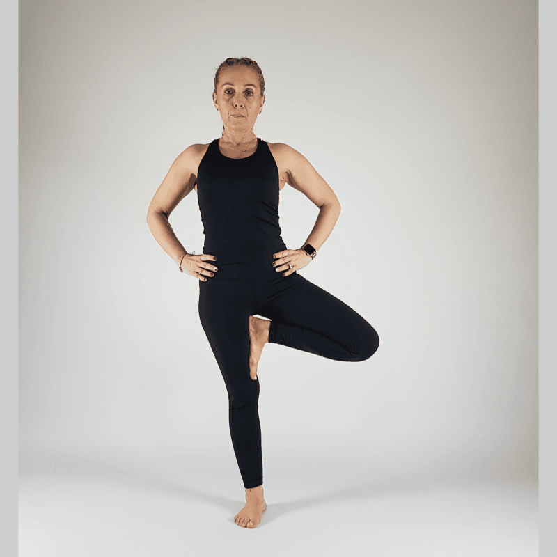 Tree Pose with foot placed on inner calf and hands at heart.