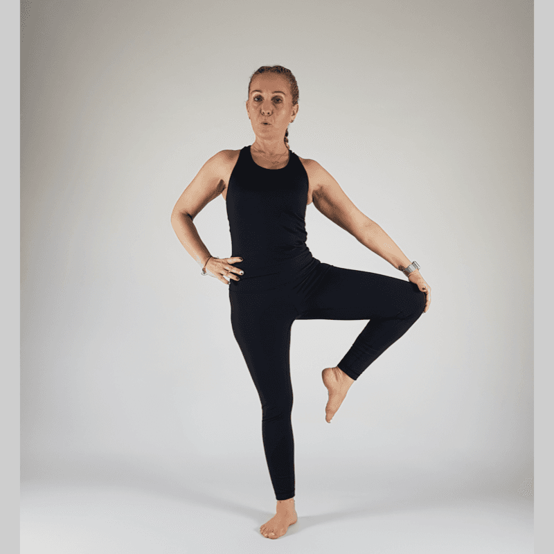Tree Pose Prep with foot on calf and hands on hips.