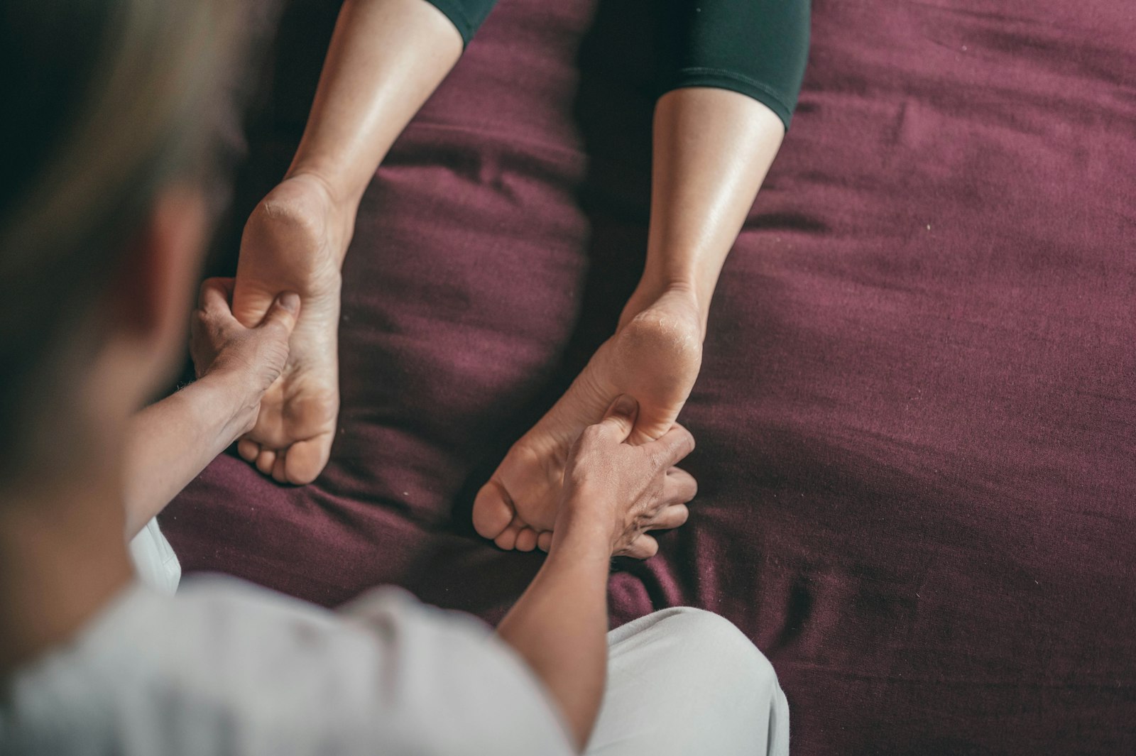 Yoga student in a supported, prop-assisted restorative pose with soft, knee-safe positioning