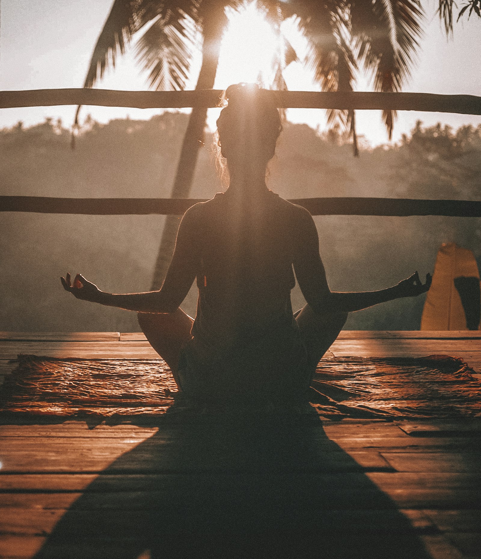 Woman meditating with hands on her chest at sunrise